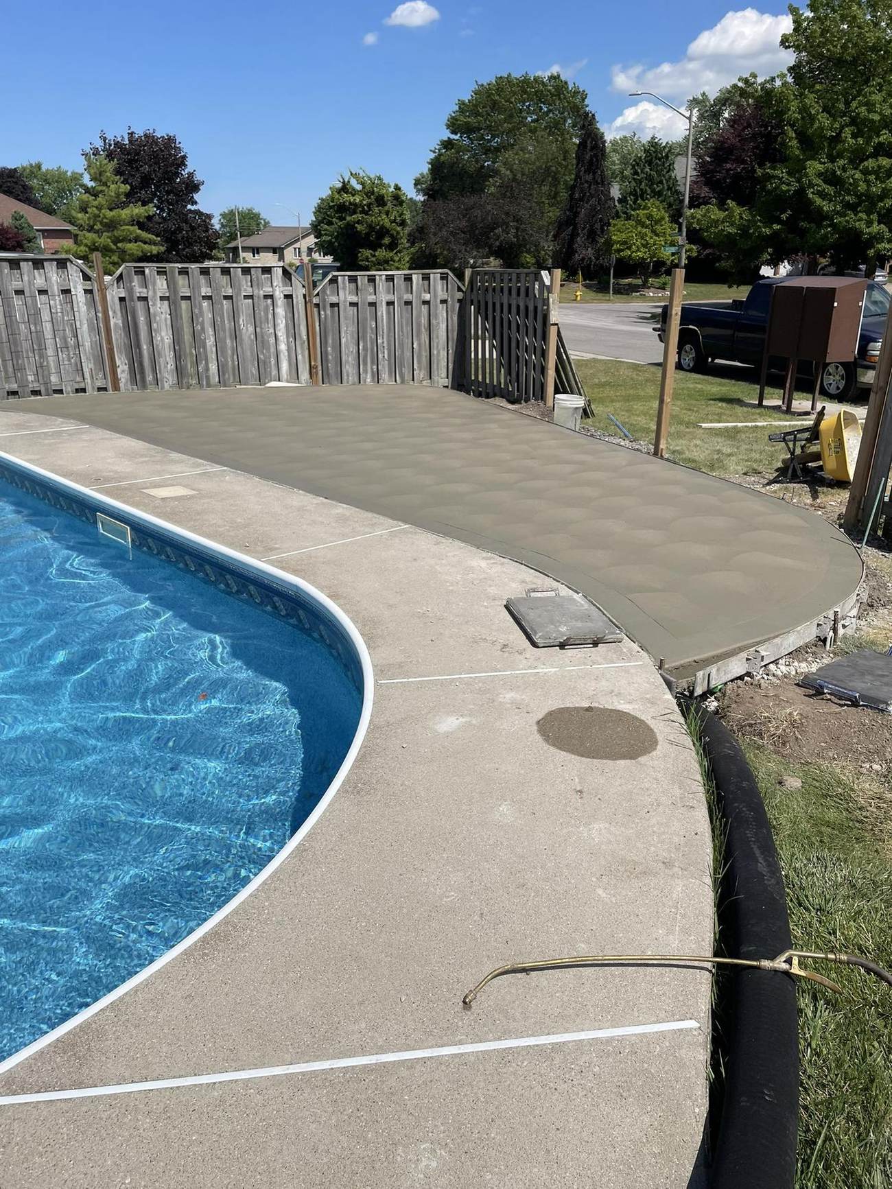 Curved concrete deck around a kidney-shaped pool