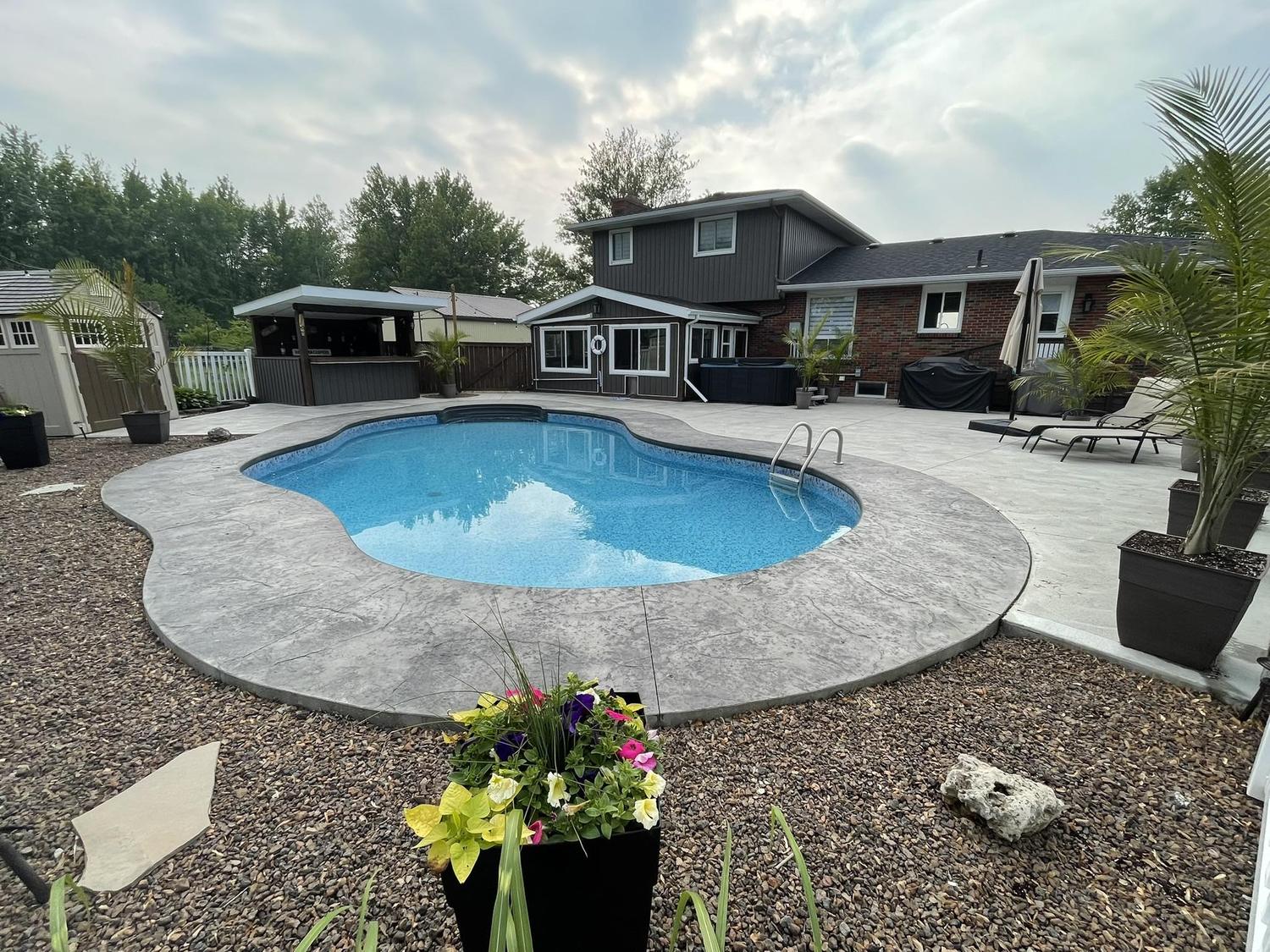 Backyard pool with new stamped concrete deck