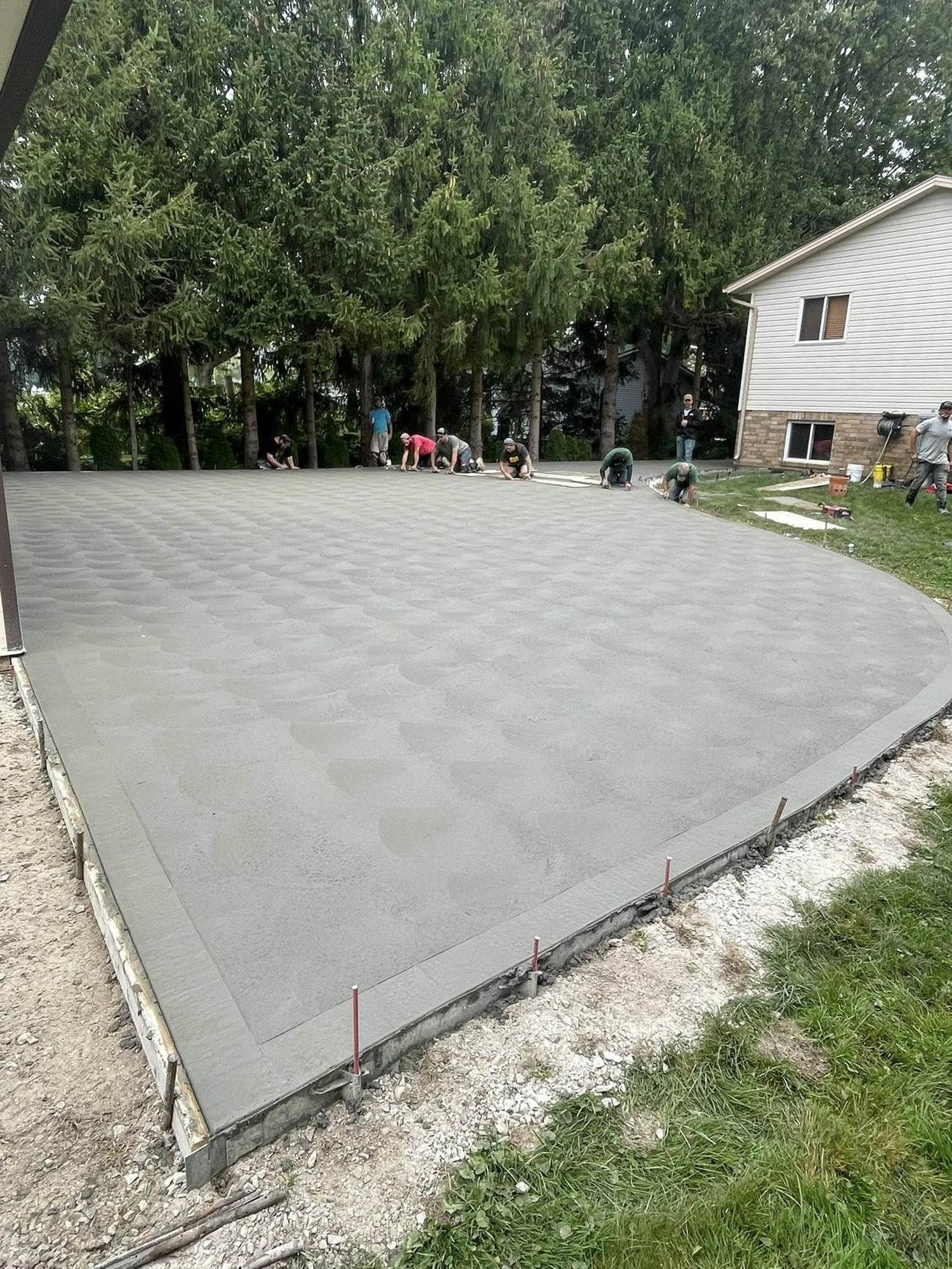 Large backyard concrete patio at dusk