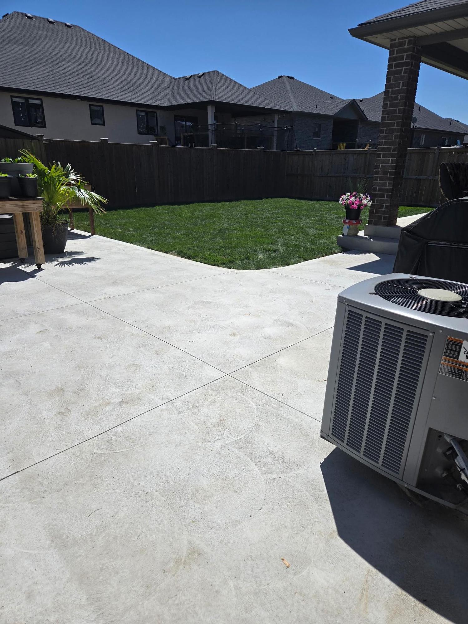 Concrete patio wrapping around a home