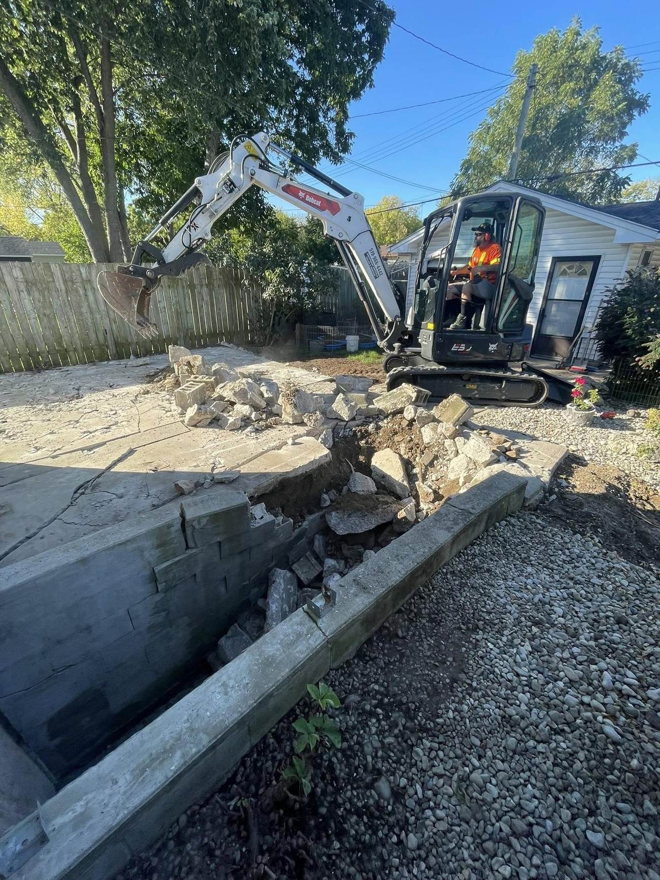 Excavator breaking out an old concrete slab