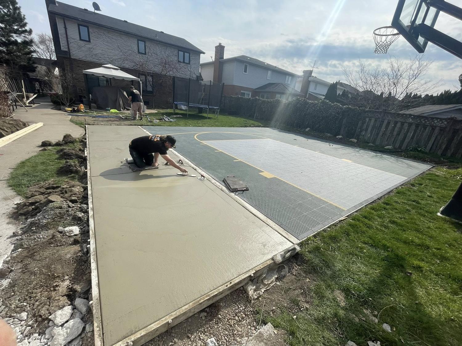 Crew hand-finishing fresh concrete