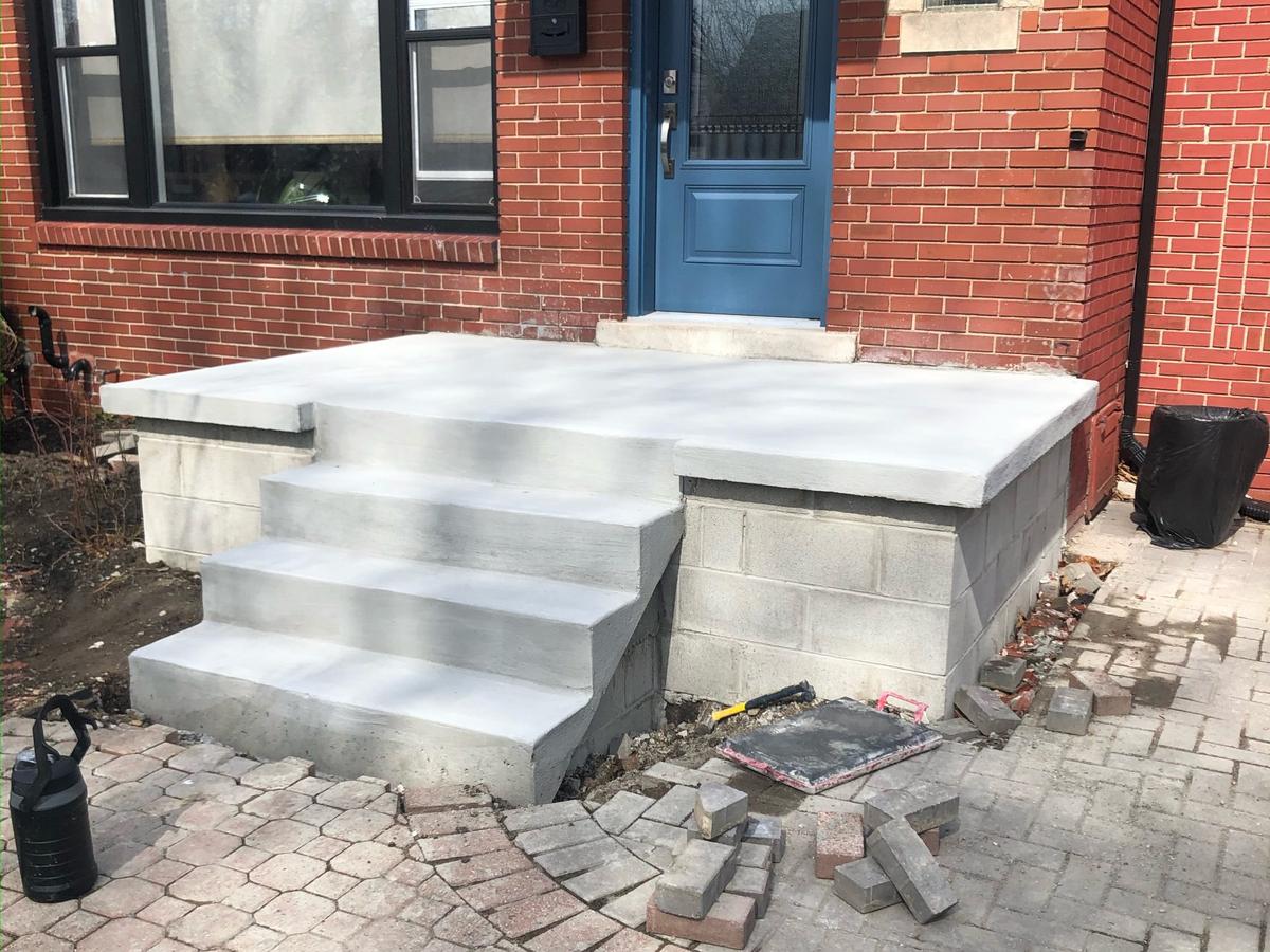 Restored concrete porch and steps on a brick home